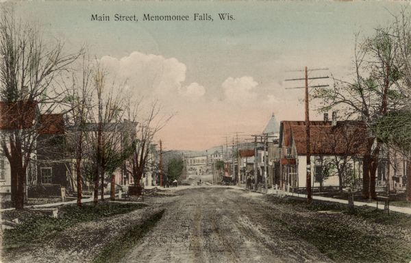 Downhill view of Main Street, lined with dwellings and businesses. Caption reads: "Main Street, Menomonee Falls, Wis."