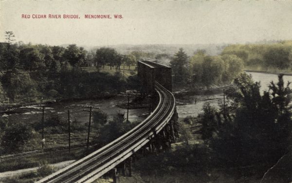Elevated view of a railroad bridge spanning the Red Cedar River. Caption reads: "Red Cedar River Bridge, Menomonie, Wis."