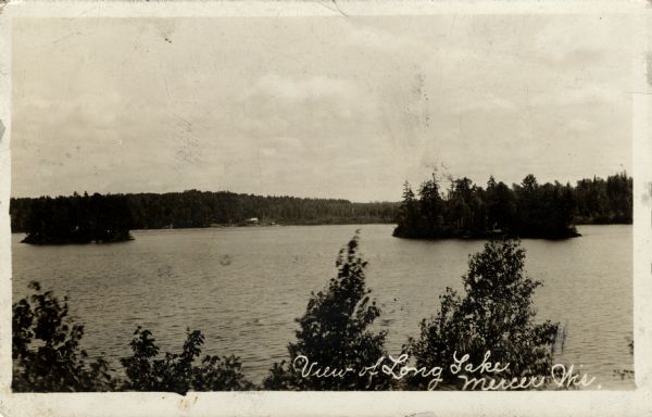 Elevated view of Long Lake with two small islands. A building is on the far shoreline. Caption reads: "View of Long Lake, Mercer, Wis."