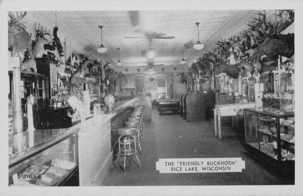 Text on front reads: "The 'Friendly Buckhorn,' Rice Lake, Wisconsin". Text on reverse reads: "No vacation trip to Northern Wisconsin is complete without a visit to the 'FRIENDLY BUCKHORN' at Rice Lake, Wisconsin. Hundreds of curios on display including the 'WORLD'S RECORD DEER.'" The Buckhorn Tavern had an amazing display of taxidermy and curios including some hoaxes, a shovel-tailed snowsnake, a dingbat and a fur herring. Originally the Buckhorn was a billiard parlor.