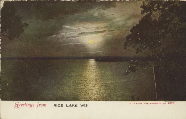 Text on front reads: "Greetings from Rice Lake Wis." and "E.C. Kropp, Pub. Milwaukee." Sunset over Rice Lake with a dramatic sky and clouds. The sun is reflecting on the water and trees frame the view.
