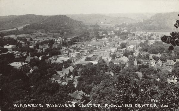 Text on front reads: "Birdseye, Business Center, Richland Center, Wis." An aerial view, looking north, of the town situated between tree covered hills. The Pine River is on the left.