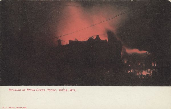 Text on front reads: "Burning of the Ripon Opera House, Ripon Wis." A dramatic scene at night, with flames consuming an Opera House which is silhouetted against an orange background.