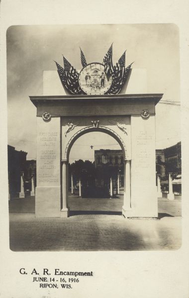 Text on front reads: "G.A.R. Encampment. June 14-16, 1916. Ripon, Wis." An arched monument honoring the Grand Army of the Republic, crowned with the Seal of the State of Wisconsin and American flags, located in the Public Square. Phrases on the monument read, one the left side of arch: "Fifty Three Regiments Infantry", "Thirteen Batteries Light Artillery", "One Company Sharpshooters". Phrases on the right side of arch read: "Four Regiments Cavalry", One Regiment Heavy Artillery", and (unreadable).