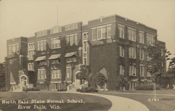 Text on front reads: "North Hall, State Normal School, River Falls, Wis." A view of the vine-covered facade and side of North Hall at the State Normal School. The school is built of red brick and stone work decorates the top. A curved sidewalk runs to the front. The Wisconsin State Normal School, known as such between the years 1874-1927, is now UW-River Falls. Added to the National Register of Historic Places in 1986.