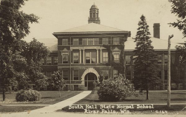 Text on front reads: "South Hall State Normal School, River Falls, Wis." A view of the vine-covered front of South Hall at the State Normal School. The school is built of red brick and stone work decorates the front with a belfry. Trees, shrubs and sidewalks can be seen. The Wisconsin State Normal School, known as such between the years 1874-1927, is now UW-River Falls. Added to the National Register of Historic Places in 1976.