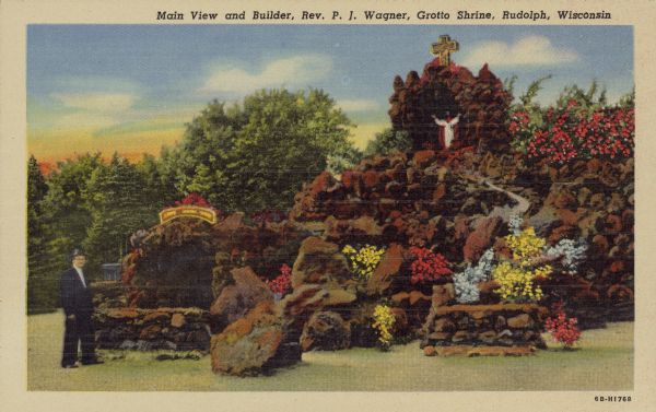 Text on front reads: "Main View and Builder, Rev. P.J. Wagner, Grotto Shrine, Rudolph, Wisconsin." A rock and flower shrine with a statue of Jesus in a niche at the top. The builder, Rev. P.J. Wagner, is standing on the left. Trees are in the background.