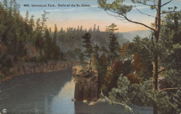 Text on front reads: "Interstate Park. Dells of the St. Croix." Elevated view of the Dells of the St. Croix River between Wisconsin and Minnesota. Text on reverse: "State Park Series. Interstate Park. (Located on the St. Croix River at St. Croix Falls, Wis. and Taylors Falls, Minn.) 700 Acres. Seen either from one of the pleasure boats as we float down the river, or from the crest of the high bluffs, this scenery presents a very striking appearance. The cluster of perpendicular rock-columns just at a sharp turn of the river are of most remarkable formation. Here they have stood for ages defying the swift onflowing waters, serving somewhat as mighty guards to this interesting scenery we now enjoy as our State Park."