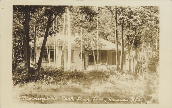 Text on front reads: "Morningside Park, Long Lake, Sarona, Wis." A home in the trees with foliage in the foreground.