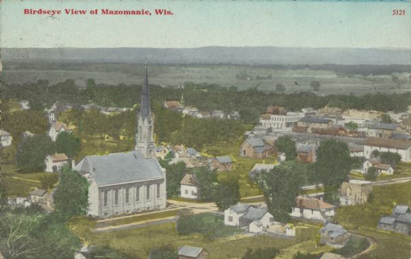 Text on front reads: "Birdseye view of Mazomanie, Wis." Elevated view of streets, churches, businesses and dwellings. Beyond the town are fields and hills.