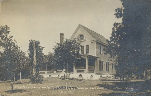 Text on front reads: "Mr. Branum's Cottage, Lauderdale Lake, Wis." A dwelling with a large porch, surrounded by trees.