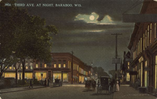 Text on front reads: "Third Ave. At Night, Baraboo, Wis." A city scene at night, with horse-drawn carriages in the streets and pedestrians on the sidewalks. The windows in the buildings are aglow and the moon is shining through a gap in the clouds.