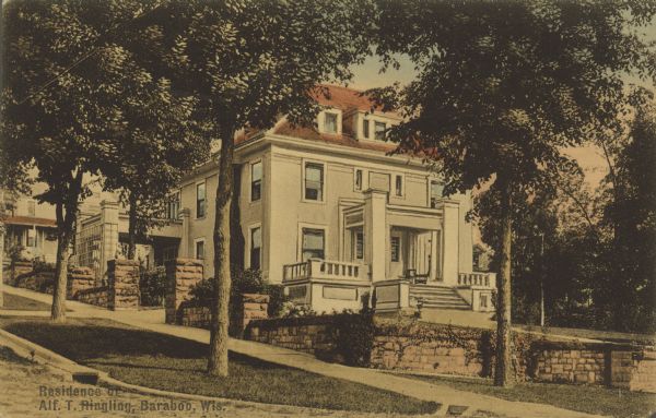 Text on front reads: "Residence of Alf. T. Ringling, Baraboo, Wis." A three-story home on a terraced lot with stone walls. The neighborhood is built on a hill with sidewalks, trees and more homes in the distance.