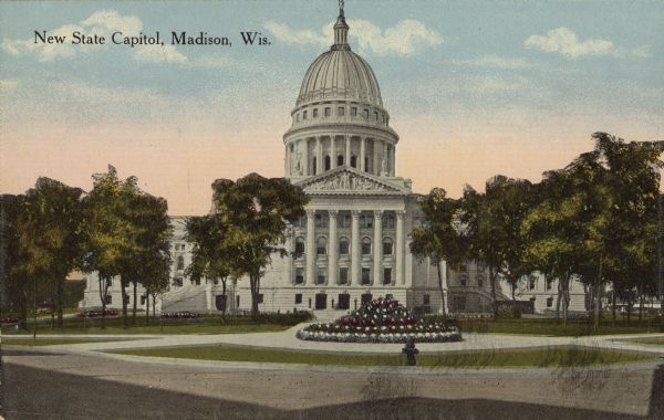 Text on front reads: "New State Capitol, Madison, Wis." The Third State Capitol on the Capitol Square. Construction began in 1906 and was completed in 1917. The building is surrounded by trees, sidewalks, lawns, streets and many gardens.