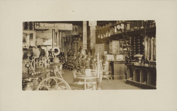 Handwriting on back reads: "Interior of Kahnt's Shoe Store, Seymour, Wis. - at about the turn of the century." The store is filled with merchandise. A sign reads: "The Sherwin-William Paint." This is probably Kahnt's Department Store.