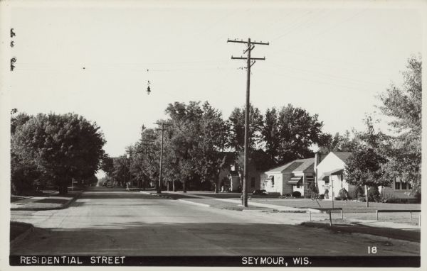 Text on front reads: "Residential Street,  Seymour, Wis." A street view of a neighborhood with homes, sidewalks and trees.