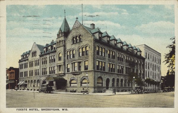 Text on front reads: "Foeste Hotel, Sheboygan, Wis." A corner view of the Foeste Hotel, which has many arched windows, and dormer windows above. An automobile and truck are parked at the curb.