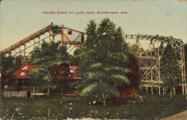Text on front reads: "Figure Eight at Lake View, Sheboygan, Wis." A rollercoaster at Lake View Park with trees and a flower filled lawn in the foreground. The cars run through a figure 8 shaped course before returning to the boarding station.