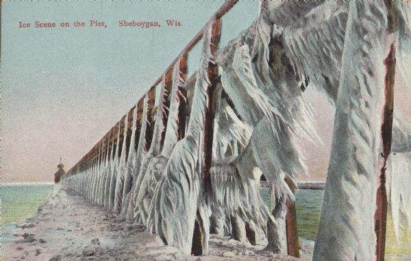 Text on front reads: "Ice Scene on the Pier, Sheboygan, Wis." Ice streamers hang from a pier leading to a lighthouse on Lake Michigan's shore.