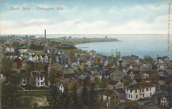Text on front reads: "North Point — Sheboygan, Wis." Elevated view of a Niagara limestone shelf of rock that rises above Lake Michigan. This rarely occurs and is of the same bedrock that forms Niagara Falls. In the foreground are buildings and dwellings of the city.