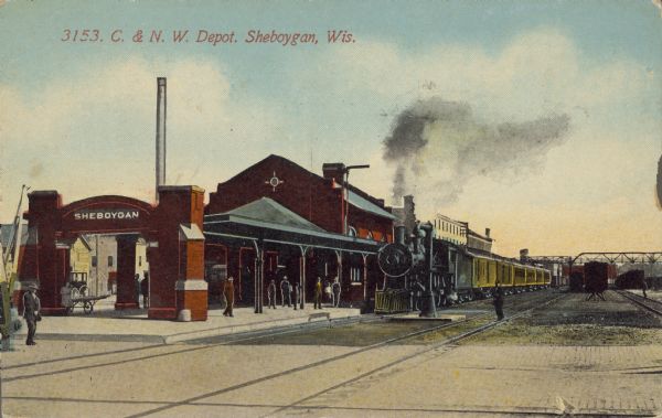 Text on front reads: "C. & N. W. Depot. Sheboygan, Wis." The Chicago & North Western railroad depot, built of brick in 1906. A train is stopped, pedestrians are on the platform and a railroad worker is on the tracks.