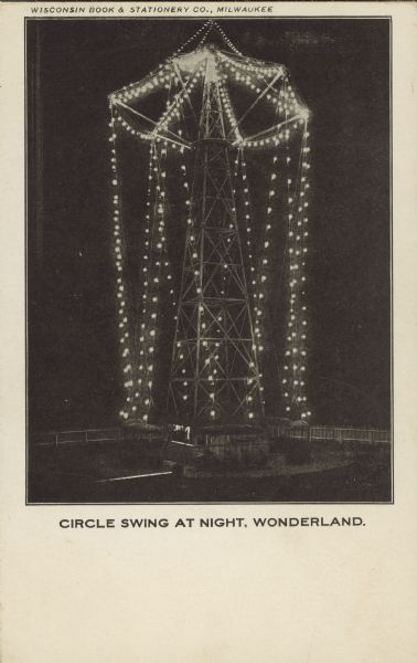 Text on front reads: "Circle Swing at Night, Wonderland." An amusement ride with swings is lit up with electric bulbs at night. This amusement park had many names over 34 years, and was called Wonderland from 1905 to 1909. It was abandoned in 1916.