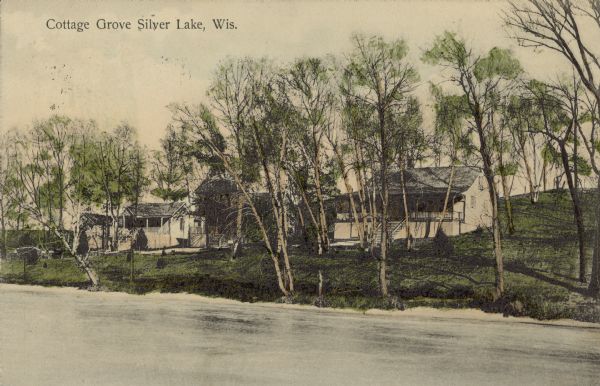 Text on front reads: "Cottage Grove Silver Lake, Wis." A colorized view of cottages on the shore of a lake. Chromolithograph.