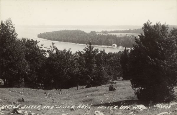 Text on front reads: "Little Sister and Sister Bays, Sister Bay, Wis." A view from a hill of the shoreline of Green Bay, Lake Michigan. 