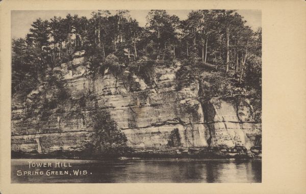 Text on front reads: "Tower Hill, Spring Green, Wis." View across water towards a rocky formation along the Wisconsin River in Tower Hill State Park.
