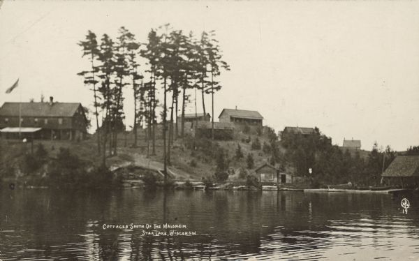 Text on front reads: "Cottages South of the Waldheim, Star Lake, Wis." View across lake towards boathouses and docks on the shore of Star Lake, with cottages and the Hotel Waldheim on the hill above. Tall pine trees are along the bank.