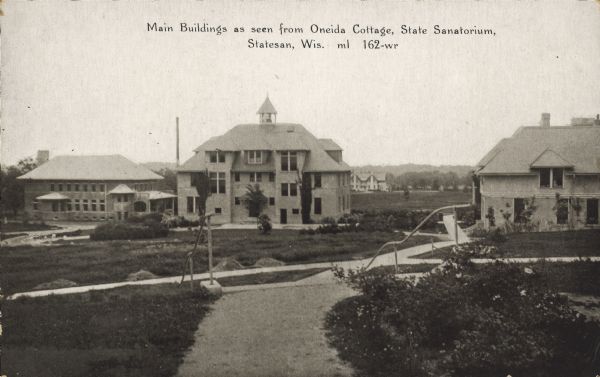 Text on front reads: "Main Buildings as seen from Oneida Cottage, State Sanatorium, Statesan, Wis." A view of the Wisconsin State Tuberculosis Sanatorium, also known as “Statesan." The building in the center is the Administration Building. It was the only state run Sanatorium in Wisconsin. It opened on November 7, 1907 and closed in the fall of 1957.