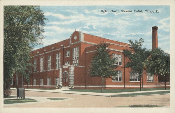 Text on front reads: "High School, Stevens Point, Wis." Completed in 1923, the Collegiate Gothic building was built of brick. Locally called the Annex, it was constructed to alleviate overcrowding at the High School. Together with a temporary building, the three buildings were referred to as Emerson School. It was demolished in 2002.