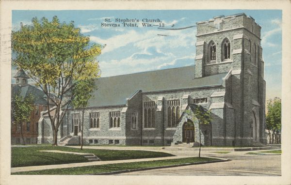 Text on front reads: "St. Stephen's Church, Stevens Point, Wis." The limestone church was built in the Neogothic Revival style in 1923. A large brick building is to the left of the church.