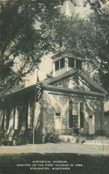 Text on front reads: "Historical Museum, Erected as the First Church in 1858. Stoughton, Wisconsin." Handwritten on reverse: "Look this [??]t history of Stoughton. This was a Universalist Church before it became a museum. It was organized May 16-1858 with 34 members. Luke Stoughton donated the south half of 2 lots." The Stoughton Universalist Church was built in 1858 of cream brick in the Greek Revival style. It is now the Stoughton Historical Museum. The Stoughton Historical Society was incorporated as an affiliate of the State Historical Society June 21, 1960. At that time they took possession of the building.