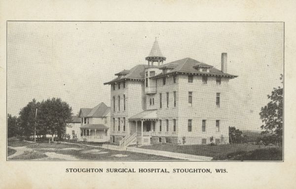 Text on front reads: "Stoughton Surgical Hospital, Stoughton, Wis." On the reverse: "Stoughton Hospital (Incorporated). All modern operations performed at moderate prices, from the most delicate cataract extraction to the largest abdominal operations. Questions gladly answered." The building is brick with three stories, a basement level and a tower on the roof. Homes and trees are on the left.