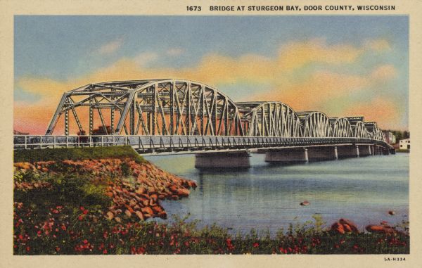 Text on front reads: "Bridge at Sturgeon Bay, Door County, Wisconsin." This bridge, also known as the Michigan Street Bridge, was built in 1929 and opened in 1931. Over the years the bridge fell into disrepair. The organization Citizens of our Bridge was formed to save the bridge and in 2005, held a concert fundraiser, the Steel Bridge Songfest. The bridge has been restored and is in use today.