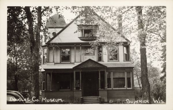 Text on the front reads: "Douglas Co. Museum, Superior, Wis." This home housed the Douglas County Museum from 1939 to 1963. They were offered the home of the A. A. Roth family to use as their museum in 1938. Alois Roth was a partner with his brother Theodore in the Roth Brothers Department Store in Superior.