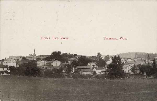 Text on front reads: "Bird's Eye View. Theresa, Wis." Elevated view of the town from a field. Homes, farms, businesses and churches can be seen with hills on the horizon.