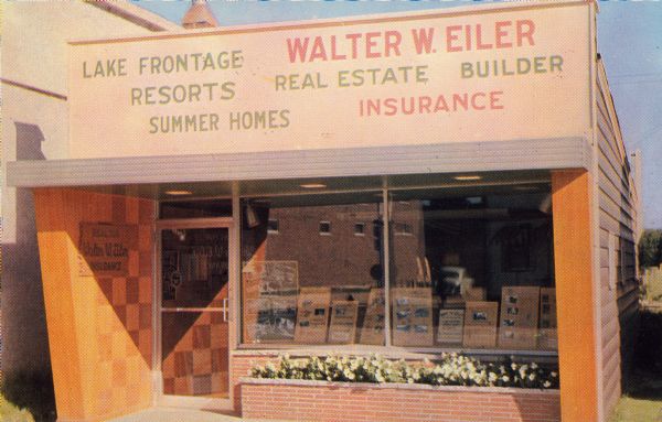 Text on reverse reads: "Walter W. Eiler. Three Lakes, Wisconsin. Realtor - Insurance. 'Recreational Real Estate in Northern Wisconsin." A storefront with a large show window and brick flower box. The window is filled with posters of properties for sale. The large sign overhead reads: "Walter W. Eiler, Real Estate, Builder, Insurance. Lake Frontage, Resorts, Summer Homes." The sign beside the door reads: "Realtor, Walter W. Eiler, Insurance."