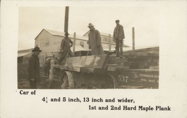 Text on front reads: "Car of 4 1/2 inch, 13 inch and wider, 1st and 2nd Hard Maple Plank." Three men are standing on a horse-drawn lumber wagon full of planks, and one man is standing on the ground. Behind them is the Tigerton Lumber Company. The back of the postcard has a printed appointment reminder that reads: "Coming! I will call on you on or about 5/15 1914. Representing the Tigerton Lumber Company, Tigerton, Wisconsin."