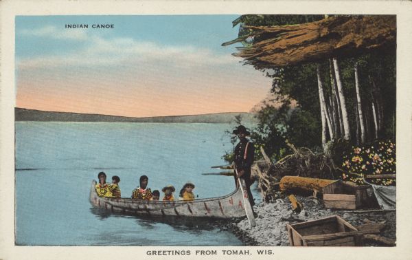 Text on front reads: "Indian Canoe" and "Greetings from Tomah, Wis." On reverse: "Camp of berry-pickers, man, wife, and children. Camp site on a beautiful lake shore, where canoe is used as a means of transportation between camp and berry fields located on distant lake shore. Thousands of bushels of blueberries, raspberries, blackberries and cranberries are picked annually for market from the wild lands of the North by Indians. Berry picking is a profitable occupation for hundreds of northern Indians."