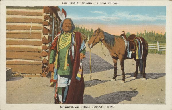 Text on front reads: "Big Chief and His Best Friend. Greetings from Tomah, Wis." A Native American man in indigenous dress poses in front of a log cabin, and his horse on the right.