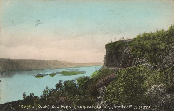 Text on front reads: "'Castle Rock,' 2nd Peak, Trempealeau, Wis., on-the-Mississippi." Elevated view towards a rock formation on the Mississippi River. Islands are in the river, and bluffs across the river are on the horizon.
