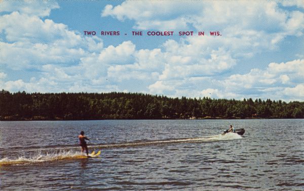 Text on front reads: "Two Rivers - The Coolest Spot in Wis." On reverse: "A speed boat, blue waters and a pair of water skis make a perfect day. Vacationland Scene." A man water skiing behind a motorboat on Lake Michigan. The shoreline is wooded.
