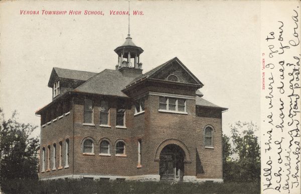 Text on front reads: "Verona Township High School, Verona, Wis." The brick high school with arched windows was organized in 1899 and the first class graduated in 1901. Handwritten on front: "Hello-This is where I go to school, how does your building compare? Thanks for your postal. Cora." 