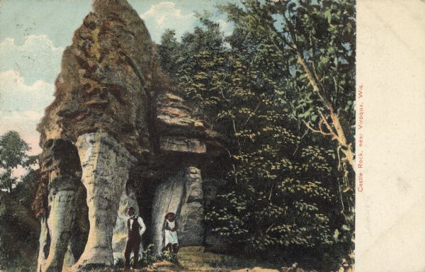 Text on front reads: "Castle Rock, near Viroqua, Wis." A man and woman pose in front of a rock formation. This formation is a "pillar" or "rock spire." It is thought to be the remnant of a cave. Several of these formations can be found in this area.