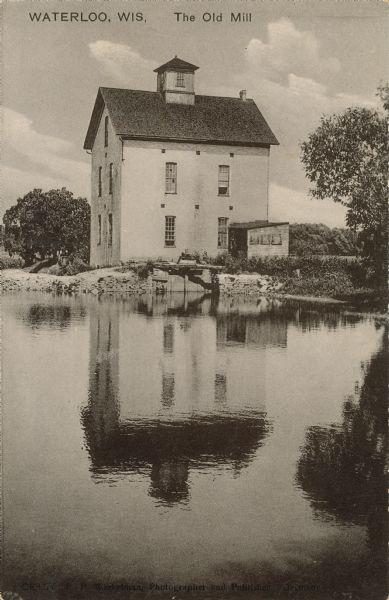 Text on front reads: "Waterloo, The Old Mill." A three-story mill on the bank of a millpond.