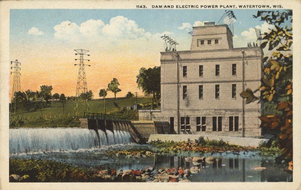 Text on front reads: "Dam and Electric Power Plant, Watertown, Wis." The Watertown Electric Company Power Plant #1 was built in 1909 of cream brick. Rolling hills and power lines are in the background on the left.