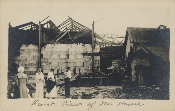 Handwriting on front reads: "Front View of Ice House." A group of men and women view the destruction as the result of a tornado that swept through the north side of the city. No lives were lost in the storm.