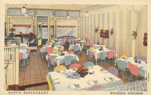 Text on front reads: "Goff's Restaurant, Waukesha, Wisconsin." On reverse: "Goff's Restaurant, Clinton Street - Waukesha, Wis. Wisconsin's Pioneer Restaurant. 50 years of service. Featuring home made pies, bread and sizzling steaks. Smorgasbord every Sunday evening. Recommended by Duncan Hines." The dining room is full of tables and chairs with place settings ready for guests. In the back of the room is the hostess stand on the left near the entrance which is fronted by large windows with decorative framing flanking the doorway. Plates on shelves and flowers in sconces decorate the walls.